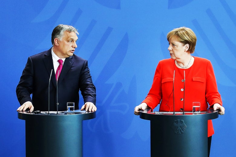 Merkel and Orbán standing at podia during a press conference.